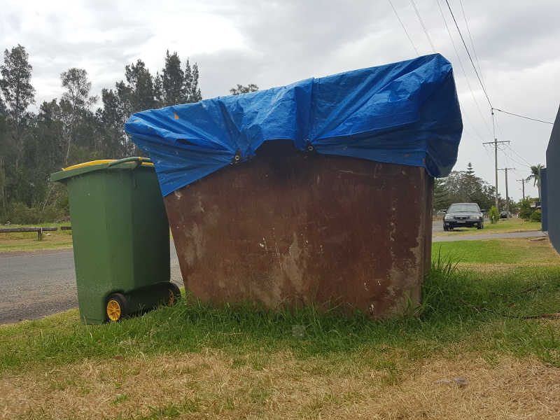 Keep others out of your skip bin by tying a tarp over it.