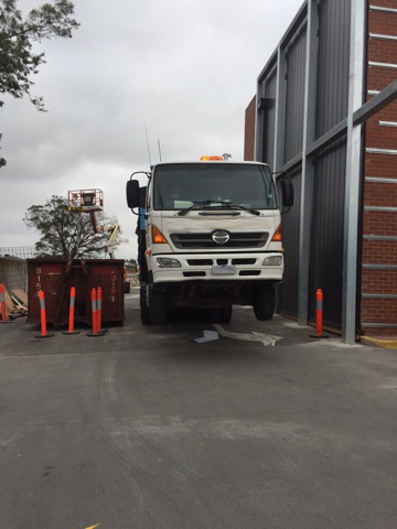 Hook-lift Truck in Preston picking up overly heavy skip bin